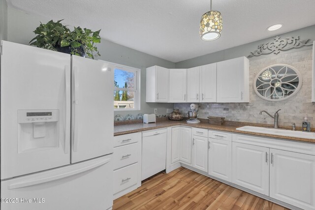 1126 Ccc Rd, Sneads Ferry, NC 28460 - kitchen featuring sink, white cabinets, pendant lighting, and white appliances