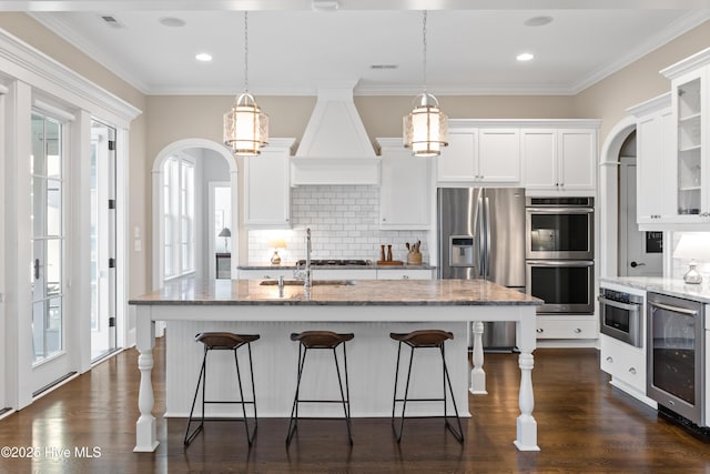 kitchen featuring stainless steel appliances, wine cooler, white cabinets, and sink