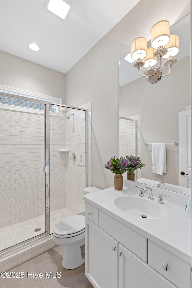 bathroom featuring toilet, a shower with door, vanity, and tile patterned floors