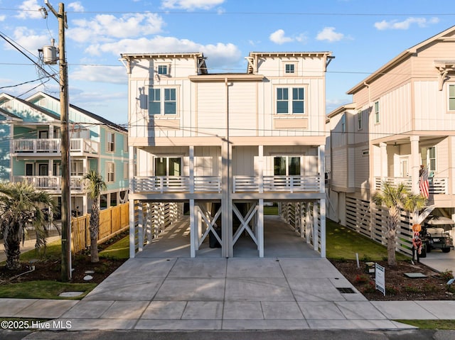 beach home featuring a carport, board and batten siding, and concrete driveway