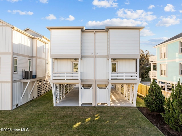 rear view of house featuring central AC and a lawn