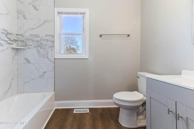 full bathroom with hardwood / wood-style flooring, toilet, vanity, and tiled shower / bath combo