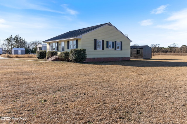 view of front of house with a storage shed and a front yard