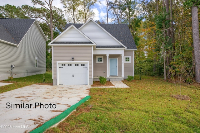 view of front of home with a front yard and a garage