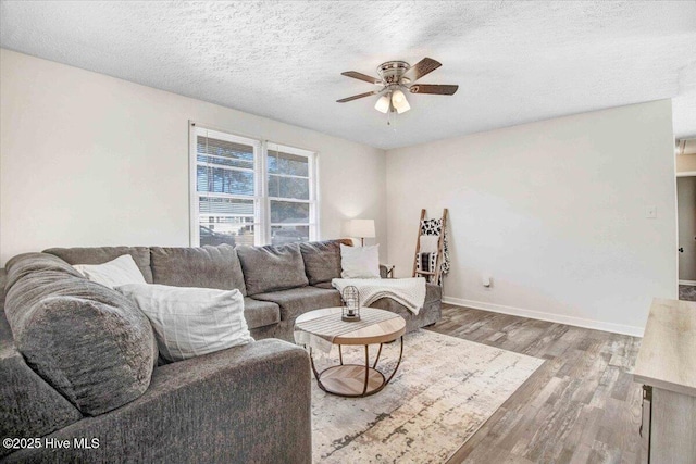 living room with a textured ceiling, hardwood / wood-style floors, and ceiling fan