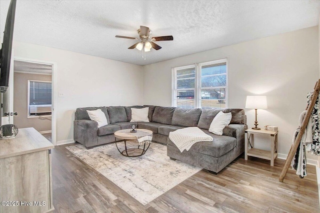 living room featuring a textured ceiling, hardwood / wood-style floors, and ceiling fan