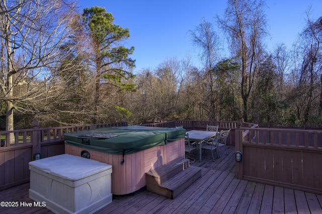 deck featuring outdoor dining space and a hot tub