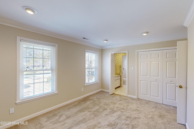 unfurnished bedroom featuring crown molding, a closet, light colored carpet, visible vents, and baseboards