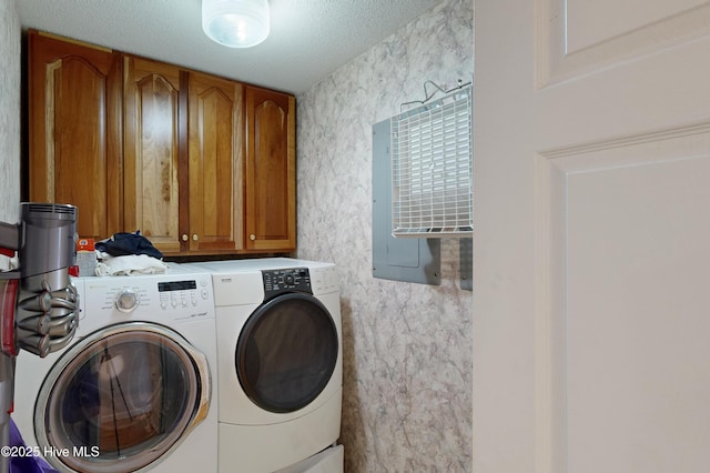 laundry area with washer and dryer, cabinets, and a textured ceiling