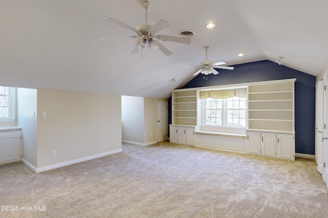 additional living space with ceiling fan, lofted ceiling, and light colored carpet