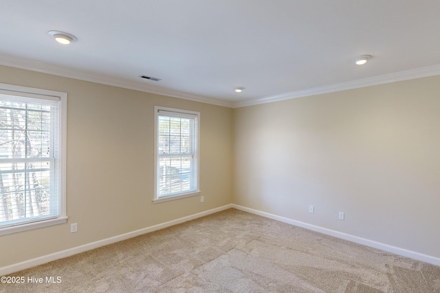 empty room featuring ornamental molding, baseboards, carpet flooring, and visible vents