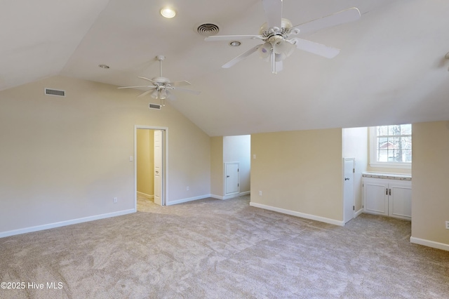 additional living space with visible vents, a ceiling fan, light colored carpet, and vaulted ceiling