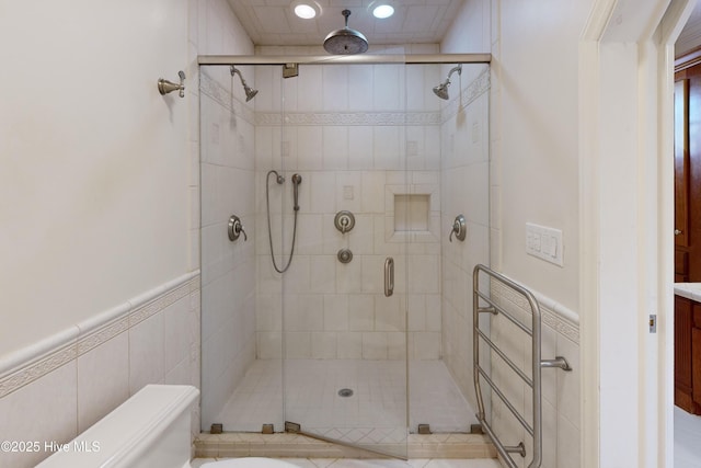 bathroom with a shower with shower door and tile walls