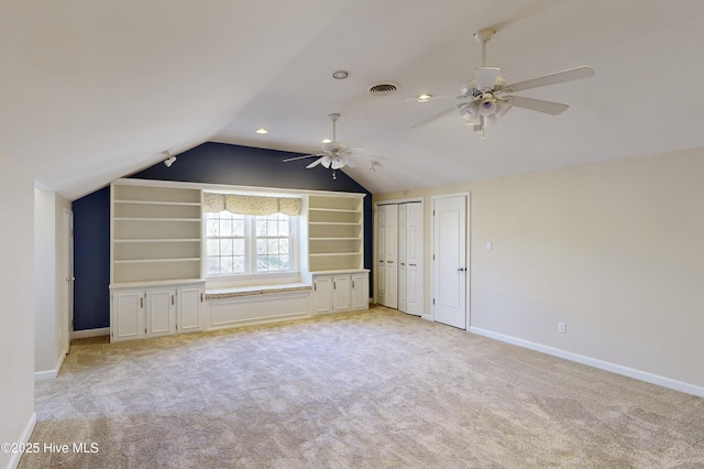 bonus room featuring ceiling fan, light colored carpet, built in shelves, and vaulted ceiling