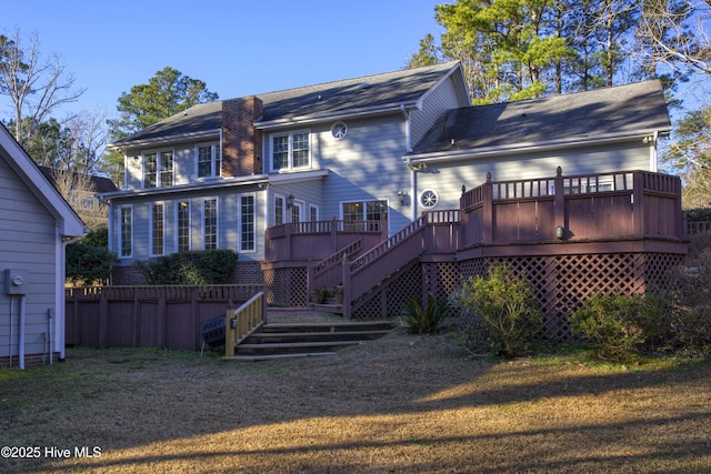 back of property featuring a yard, a wooden deck, and stairs