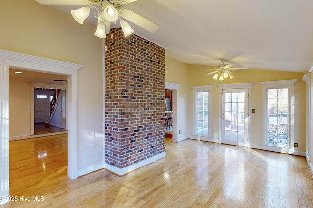 unfurnished living room with baseboards, a ceiling fan, vaulted ceiling, and light wood finished floors