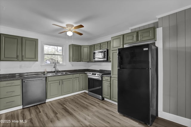 kitchen featuring green cabinets, stainless steel appliances, crown molding, light hardwood / wood-style flooring, and sink