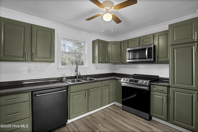 kitchen featuring stainless steel appliances, sink, ceiling fan, green cabinets, and light hardwood / wood-style flooring