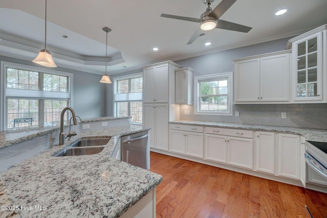 kitchen featuring appliances with stainless steel finishes, white cabinetry, sink, hanging light fixtures, and a raised ceiling