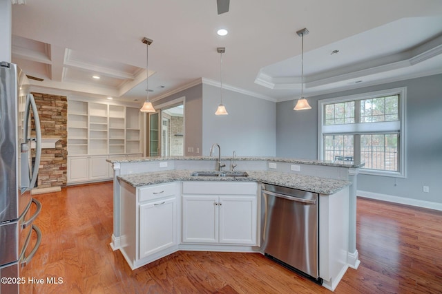 kitchen with decorative light fixtures, sink, white cabinetry, appliances with stainless steel finishes, and light stone counters