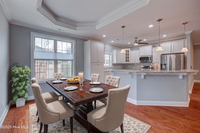 dining space with a wealth of natural light, ornamental molding, light hardwood / wood-style floors, and ceiling fan