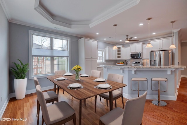 dining space featuring light wood-type flooring, ceiling fan, crown molding, and plenty of natural light