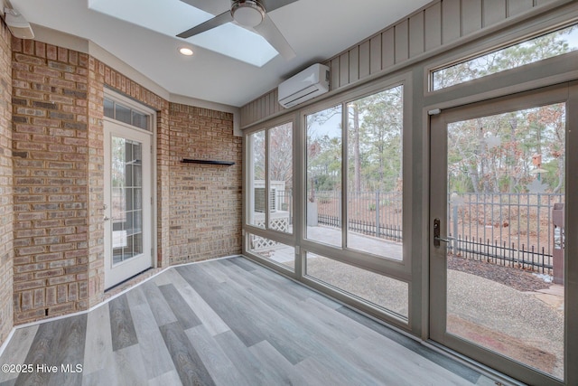 unfurnished sunroom featuring ceiling fan, a wall mounted AC, and a skylight