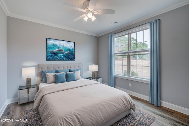 bedroom featuring ceiling fan, multiple windows, and hardwood / wood-style flooring