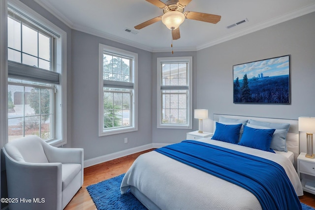 bedroom featuring light wood-type flooring, ceiling fan, and crown molding