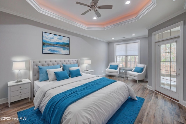 bedroom with hardwood / wood-style flooring, ceiling fan, a raised ceiling, access to exterior, and ornamental molding