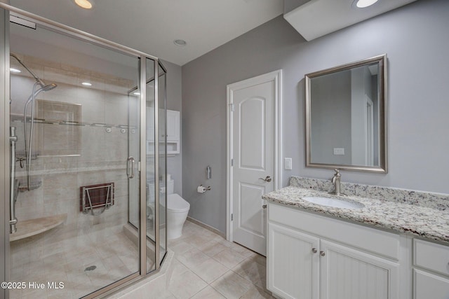 bathroom featuring toilet, a shower with door, tile patterned floors, and vanity