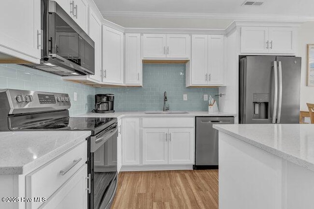 kitchen with stainless steel appliances, crown molding, sink, and white cabinets