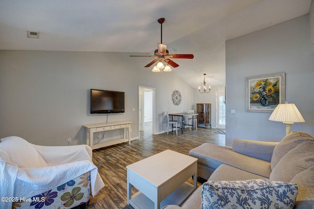 living room featuring ceiling fan with notable chandelier, dark wood-type flooring, and vaulted ceiling