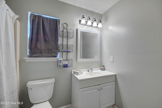 bathroom featuring toilet, vanity, and a textured ceiling