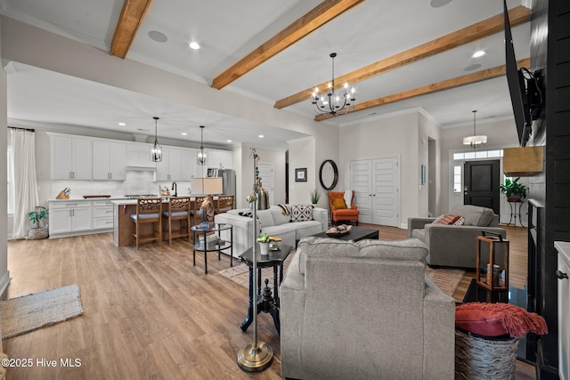 living room with beamed ceiling, a chandelier, light wood-type flooring, and crown molding