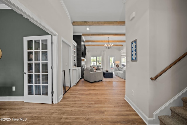 corridor featuring a notable chandelier, light hardwood / wood-style floors, and beamed ceiling