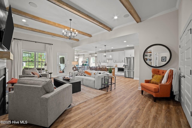 living room with an inviting chandelier, crown molding, beamed ceiling, and light hardwood / wood-style flooring