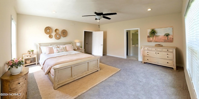 carpeted bedroom with multiple windows, ceiling fan, and connected bathroom