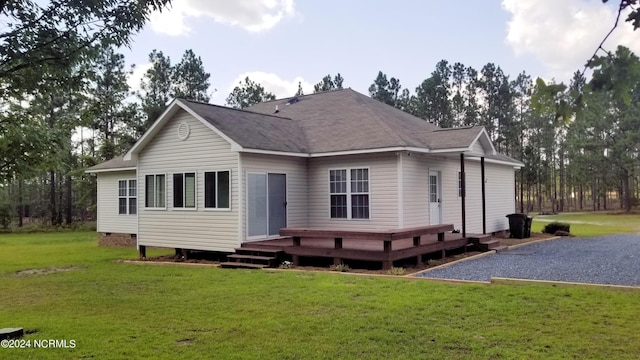 back of house with a deck and a lawn