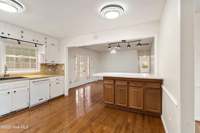 kitchen with sink, white cabinetry, tasteful backsplash, white dishwasher, and dark hardwood / wood-style floors