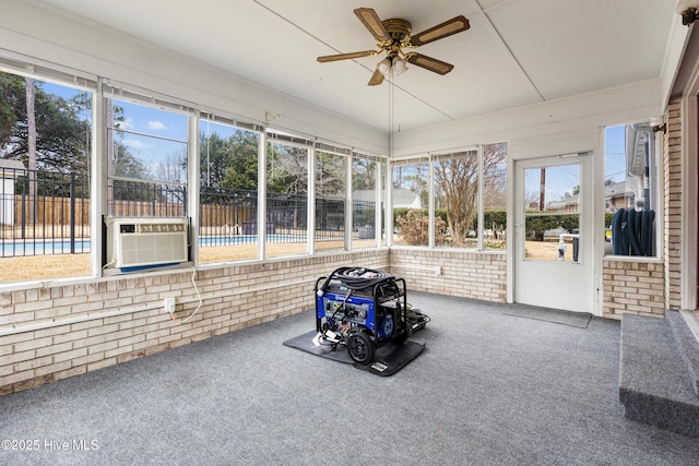 unfurnished sunroom featuring ceiling fan, cooling unit, and a wealth of natural light