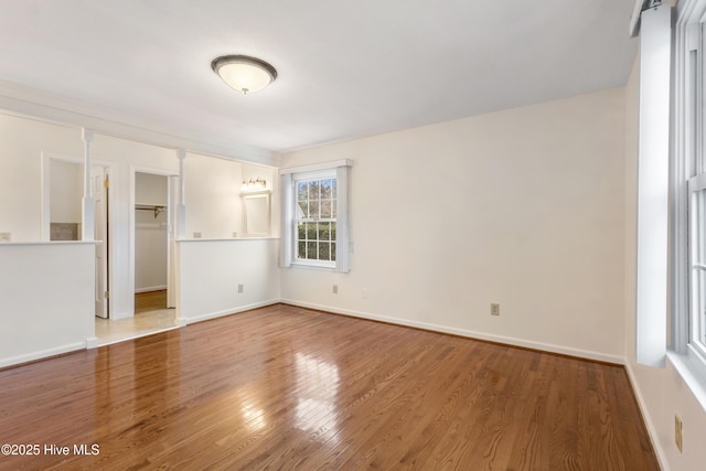 unfurnished bedroom featuring a spacious closet, a closet, and hardwood / wood-style flooring