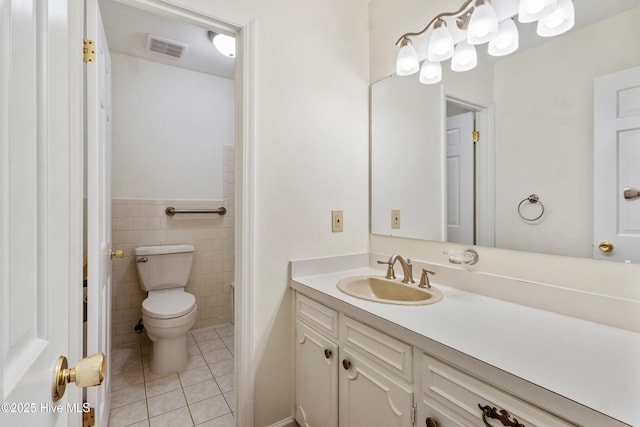 bathroom featuring tile walls, tile patterned flooring, toilet, and vanity