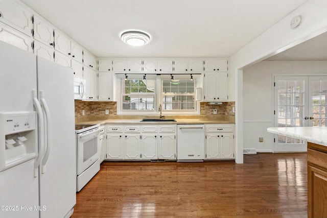 kitchen with white appliances, dark hardwood / wood-style flooring, french doors, white cabinets, and sink