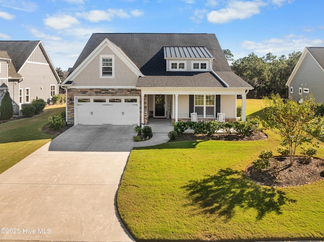 view of front of house with a front lawn, covered porch, and a garage