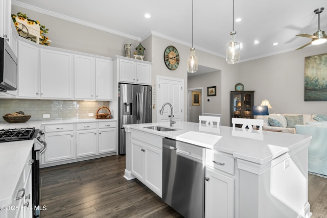 kitchen featuring white cabinetry, an island with sink, stainless steel appliances, backsplash, and sink