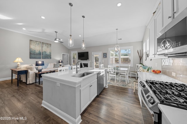 kitchen with backsplash, sink, white cabinetry, an island with sink, and stainless steel appliances