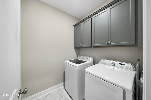 laundry room featuring washer and clothes dryer and cabinets