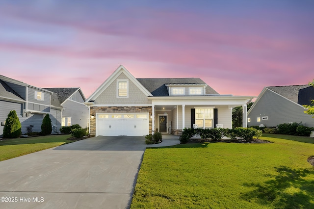 view of front of home featuring covered porch, a yard, and a garage