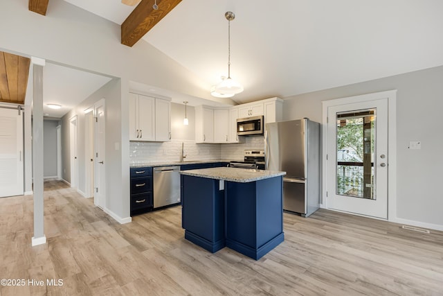 kitchen featuring appliances with stainless steel finishes, hanging light fixtures, vaulted ceiling with beams, a center island, and white cabinets